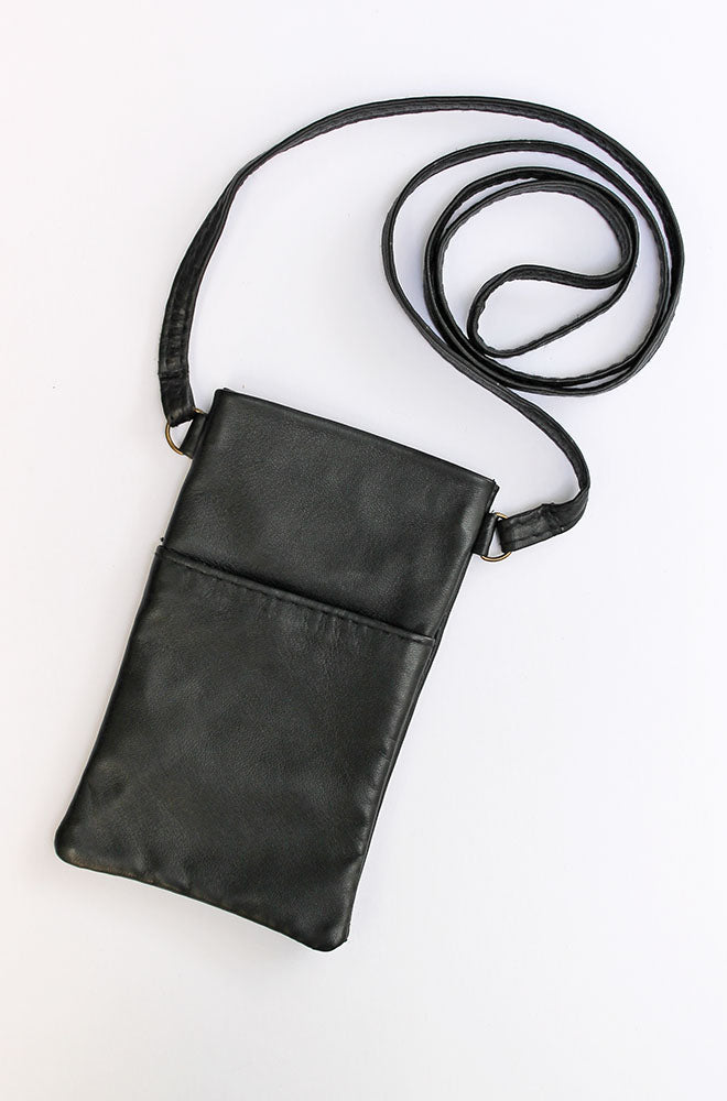 Black leather phone bag on a white background showing the size and front pocket and the crossbody strap