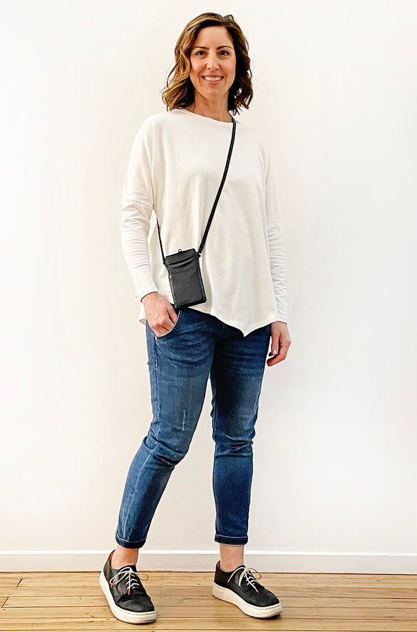woman with white top showing wearing a crossbody black Leather Phone Bag
